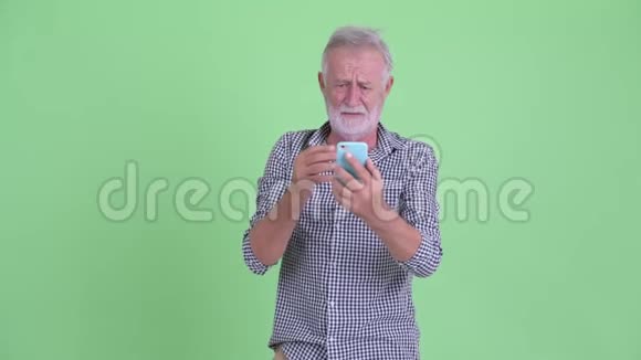 戴着大胡子的老人用电话接坏消息视频的预览图