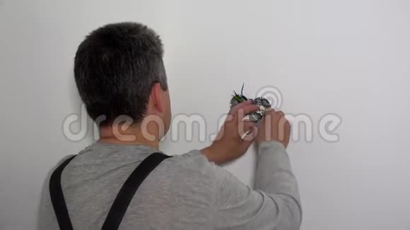 熟练的电工用螺丝刀安装电气插座视频的预览图