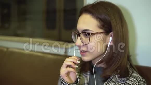 一位年轻女子正在地铁列车上通过耳机打电话旧地铁车视频的预览图