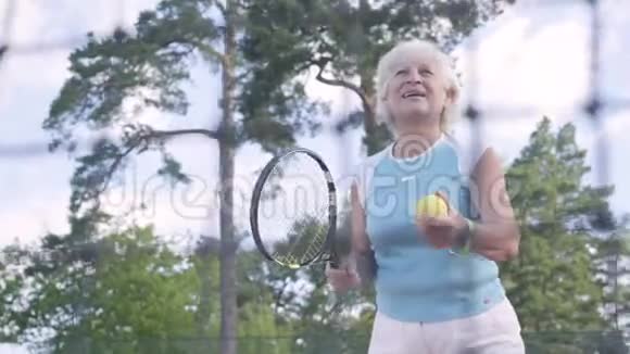 成功的快乐成熟的女人赢得了网球锦标赛这位老太太用球拍举起双手视频的预览图