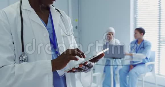 非裔美国男医生在医院使用数码平板电脑的特写视频的预览图