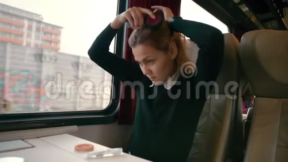 年轻的白种人女孩乘坐豪华的城际火车车厢使发型不留头发如何成为视频的预览图