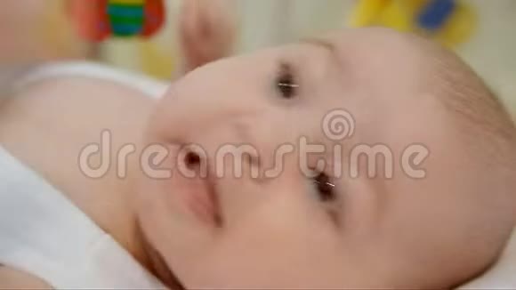 特写一张感性的脸一个可爱的婴儿咬着拳头躺在床上视频的预览图