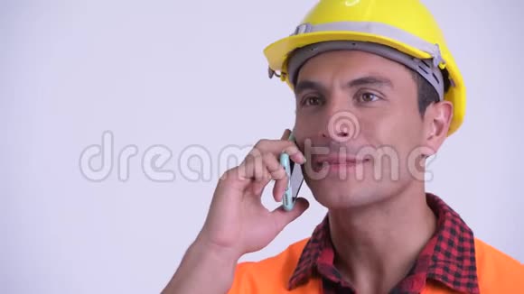 年轻快乐的西班牙裔建筑工人的脸在打电话视频的预览图