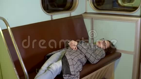 一个年轻的女人在地铁火车上睡着了旧地铁车视频的预览图