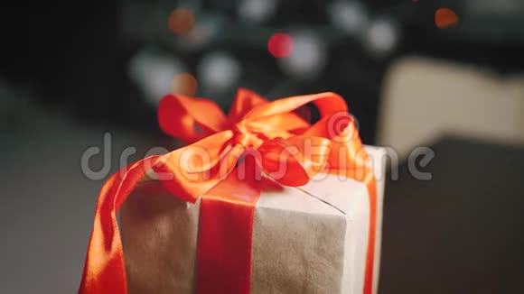 背景圣诞树上的棕色礼品盒和红色丝带视频的预览图