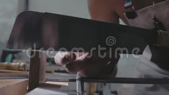 用手锯锯木板的接头的特写木匠用锯子处理木板4k4k录像慢慢慢慢视频的预览图