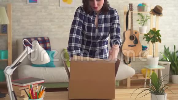 年轻女子打开一个装有包裹的盒子视频的预览图