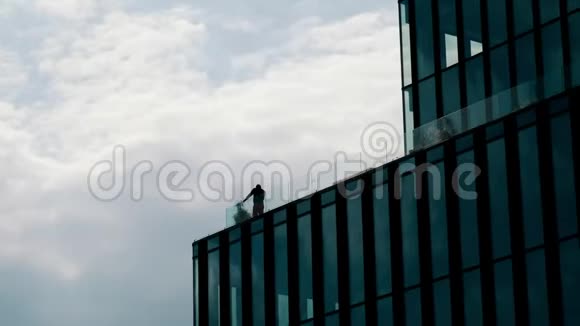 在一栋高大的办公楼的露天阳台上商人用手机说话的轮廓无法辨认视频的预览图