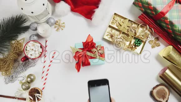在白色桌子上拍摄圣诞礼物的顶级女性视频的预览图