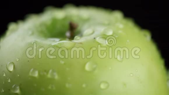 在视频中我们看到一个绿色的苹果在视频的中间水开始从顶部像淋浴一样倾泻下来黑色的视频的预览图