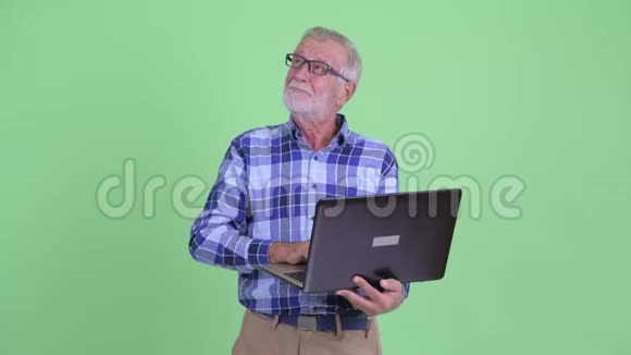 快乐的大胡子嬉皮士思考笔记本电脑视频的预览图