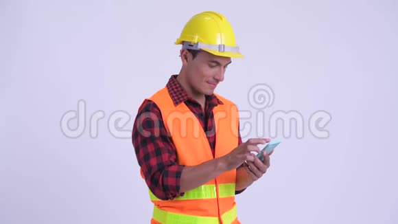 年轻快乐的西班牙男子建筑工人使用电话和获得好消息视频的预览图