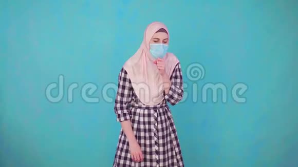 年轻漂亮的穆斯林妇女戴着医疗面具咳嗽痉挛视频的预览图