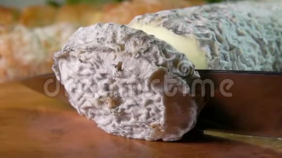 刀用稻草切成一片厚厚的山羊奶酪视频的预览图