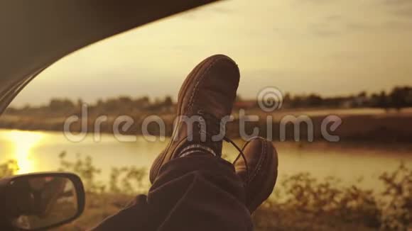 在停车休息期间穿着靴子的人的腿伸出车外视频的预览图
