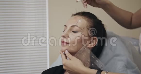 美容师在女人脸上画线条拍摄于电影摄影机12位彩色视频的预览图