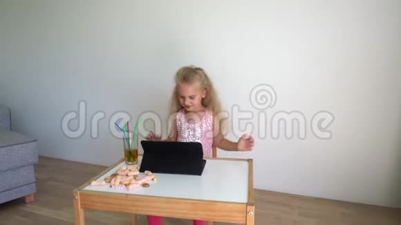 活跃的女孩打开平板电脑上的音乐在椅子上跳舞万向节运动视频的预览图