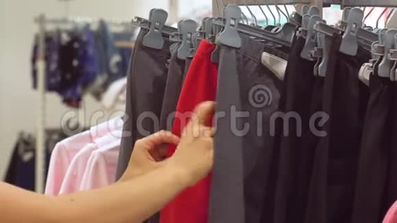 女人在商店里选择针织紧身裤手的近景视频的预览图