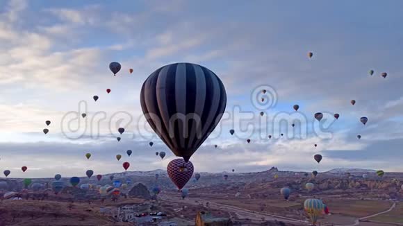 在土耳其卡帕多西亚空中观看热气球运动的童话烟囱覆盖着雪视频的预览图