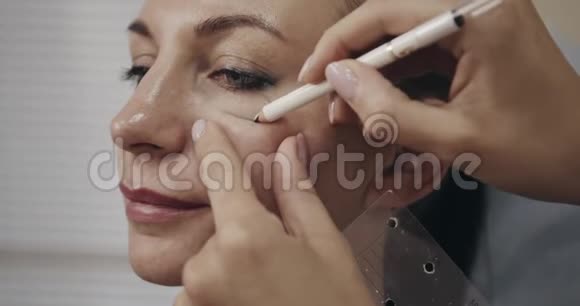 美容师在女人脸上画线条拍摄于电影摄影机12位彩色视频的预览图