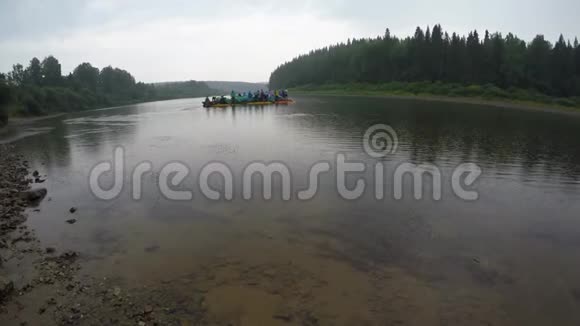 木筏上的人开始漂浮在河里从河岸看视频的预览图