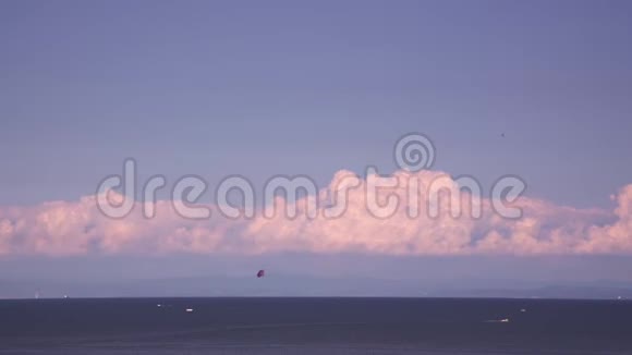 摩托艇沿着蓝色的海水航行拖着降落伞视频的预览图