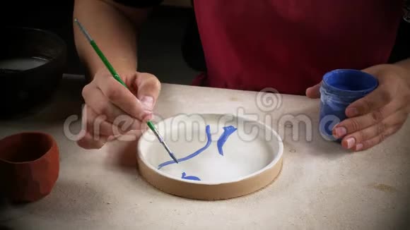 用刷子涂在泥碟上的手视频的预览图