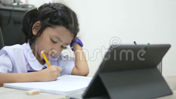 亚洲小女孩穿着泰国学生制服在木桌上做作业选择焦点浅田深视频的预览图
