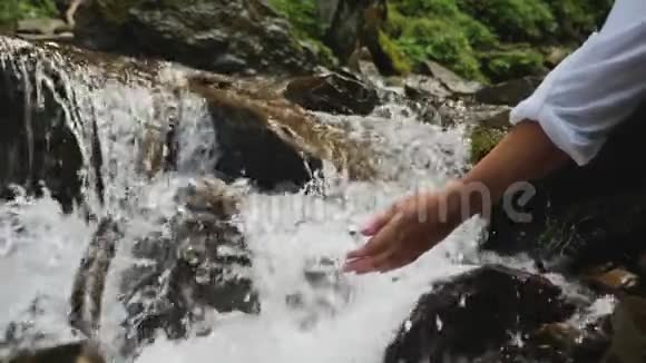 女性的手触摸着河的水流视频的预览图