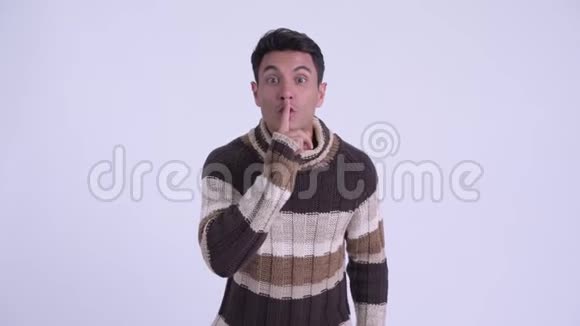 年轻快乐的西班牙男人嘴唇上有手指准备过冬视频的预览图