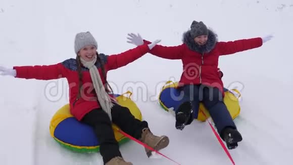 快乐的孩子们在冬天的雪地里雪橇挥手圣诞节期间家庭在冬季公园玩耍视频的预览图