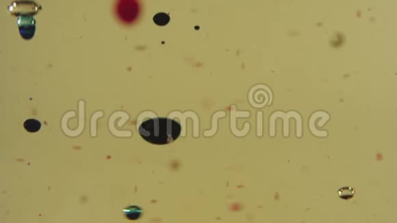 黑色红色和透明的气泡漂浮在金色液体中透明杯中的色滴快关门视频的预览图