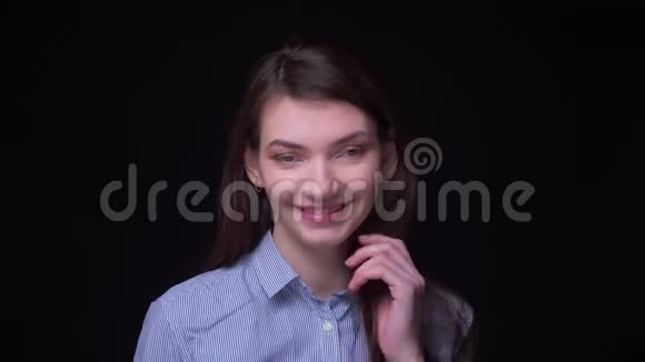 年轻的黑发女商人穿着蓝色衬衫微笑着进入镜头在黑色背景下调情视频的预览图