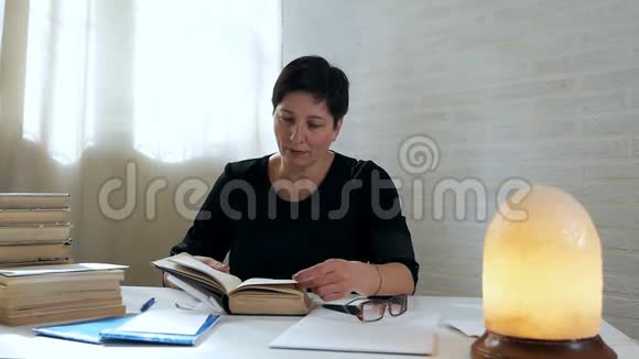 图书管理员在读者后面检查图书在昏暗的灯光下女人在图书馆里翻阅书籍视频的预览图