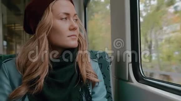 蓝眼睛的年轻女孩坐地铁或有轨电车她又累又放松慢动作视频的预览图