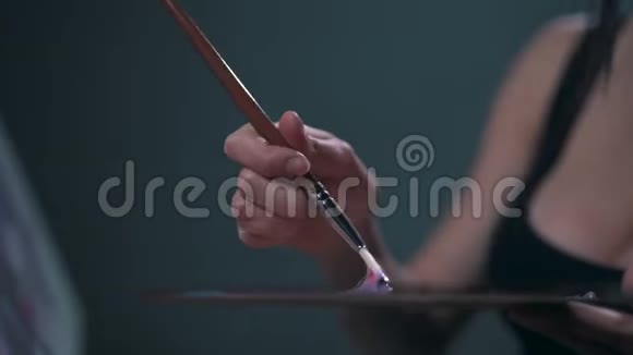 女孩用画笔特写画一幅画视频的预览图