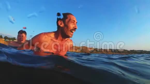 一个成年男子在日落时跳进水里一个人跳进水里在水下游泳夏季活动视频的预览图