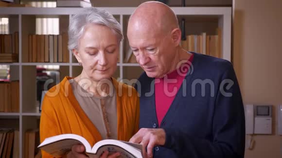 高白种人夫妇一起在图书馆看书视频的预览图