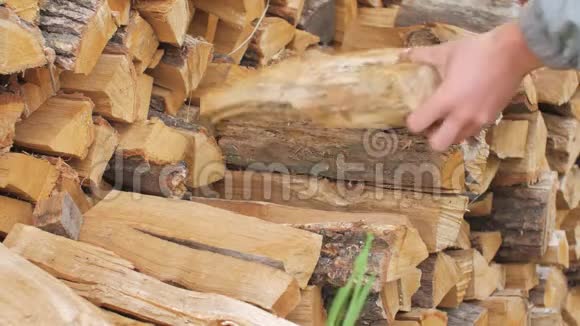 一个年轻人从木桩上取原木房子附近的一个木桩视频的预览图