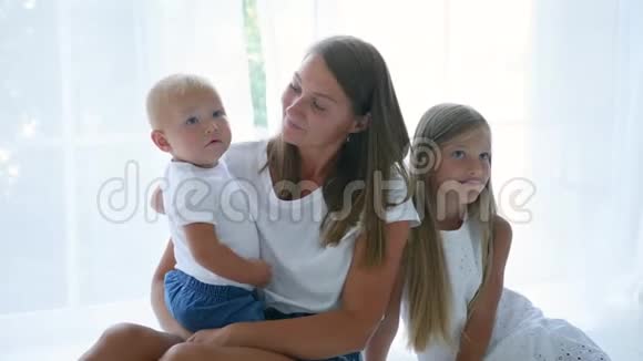 母亲带着儿子和女儿坐在家里反对视频的预览图
