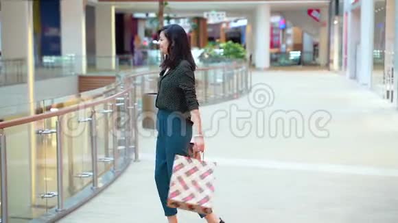 快乐的年轻女子在购物中心购物视频的预览图
