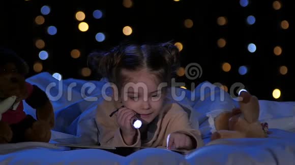小女孩晚上在床上看书博克背景慢动作视频的预览图