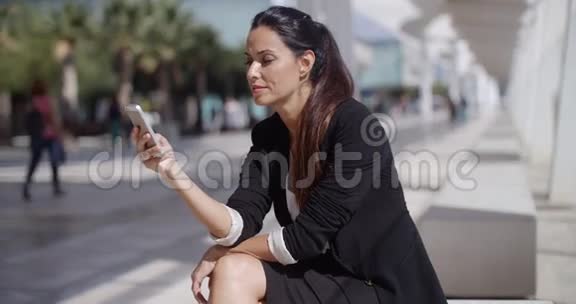 优雅的女商人检查她的电话留言视频的预览图