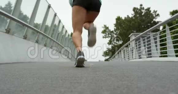 非洲裔美国妇女在城市桥上奔跑的后景视频的预览图