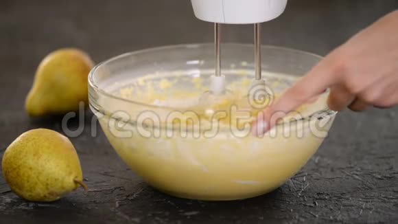 在碗里用搅拌器搅拌面团制作美味梨饼的过程视频的预览图