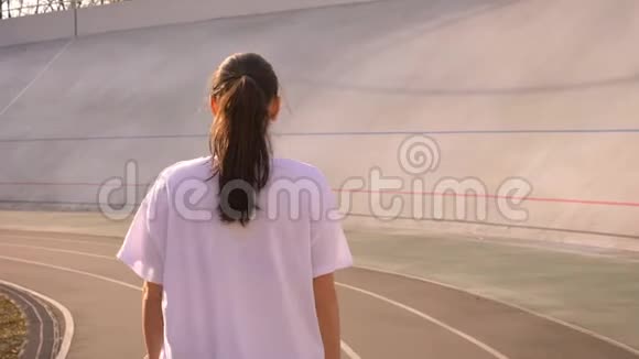 特写后景照片年轻迷人的白种人女性马尾辫走在体育场的户外视频的预览图