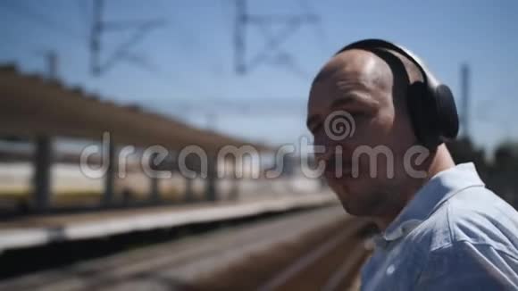 那个戴无线耳机的人在站台上等火车视频的预览图