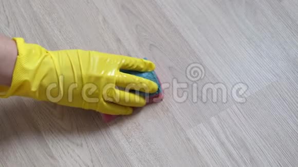 一只戴黄色手套的雌性手擦拭木表面快关门视频的预览图