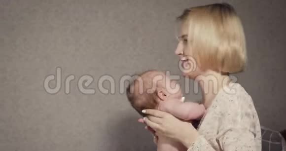 年轻的母亲抱着她的小宝贝女儿安慰她视频的预览图